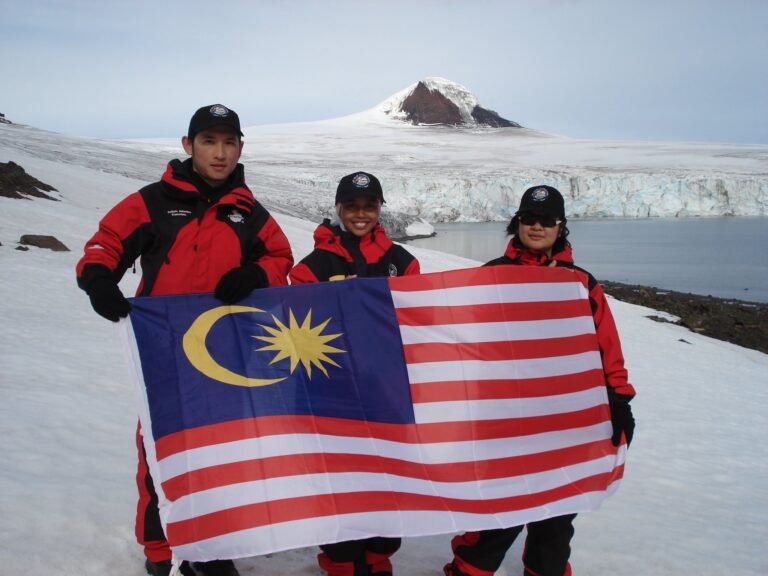 Cheah (left) and  other Malaysian researchers holding Malaysian flag at Barrientos Island